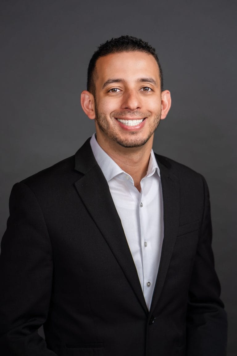 Clendi Villar, mortgage loan originator, smiling in a dark suit